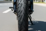 Pneu de moto com sulcos visíveis em estrada urbana para economia e segurança